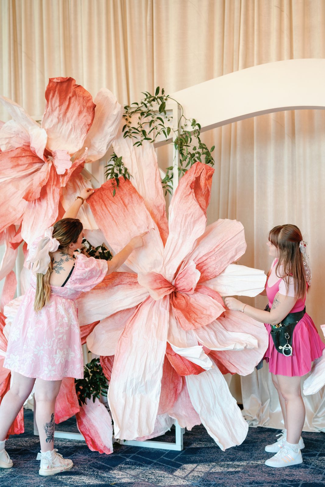 Travis and Erin working on fluffing up gigantic papery pink flowers for a backdrop.
