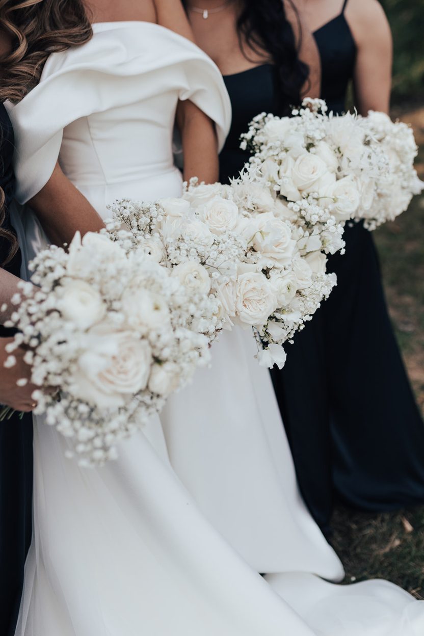 White Bouquets The bride with her bridesmaids captured from the shoulders down with their matching white bouquets.