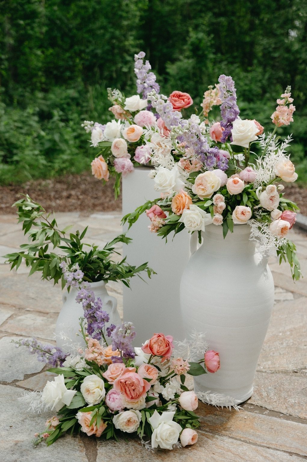 Alter Arrangements A cluster of pillars and white urns adorned with pretty pastel arrangements designed with an organic feel.