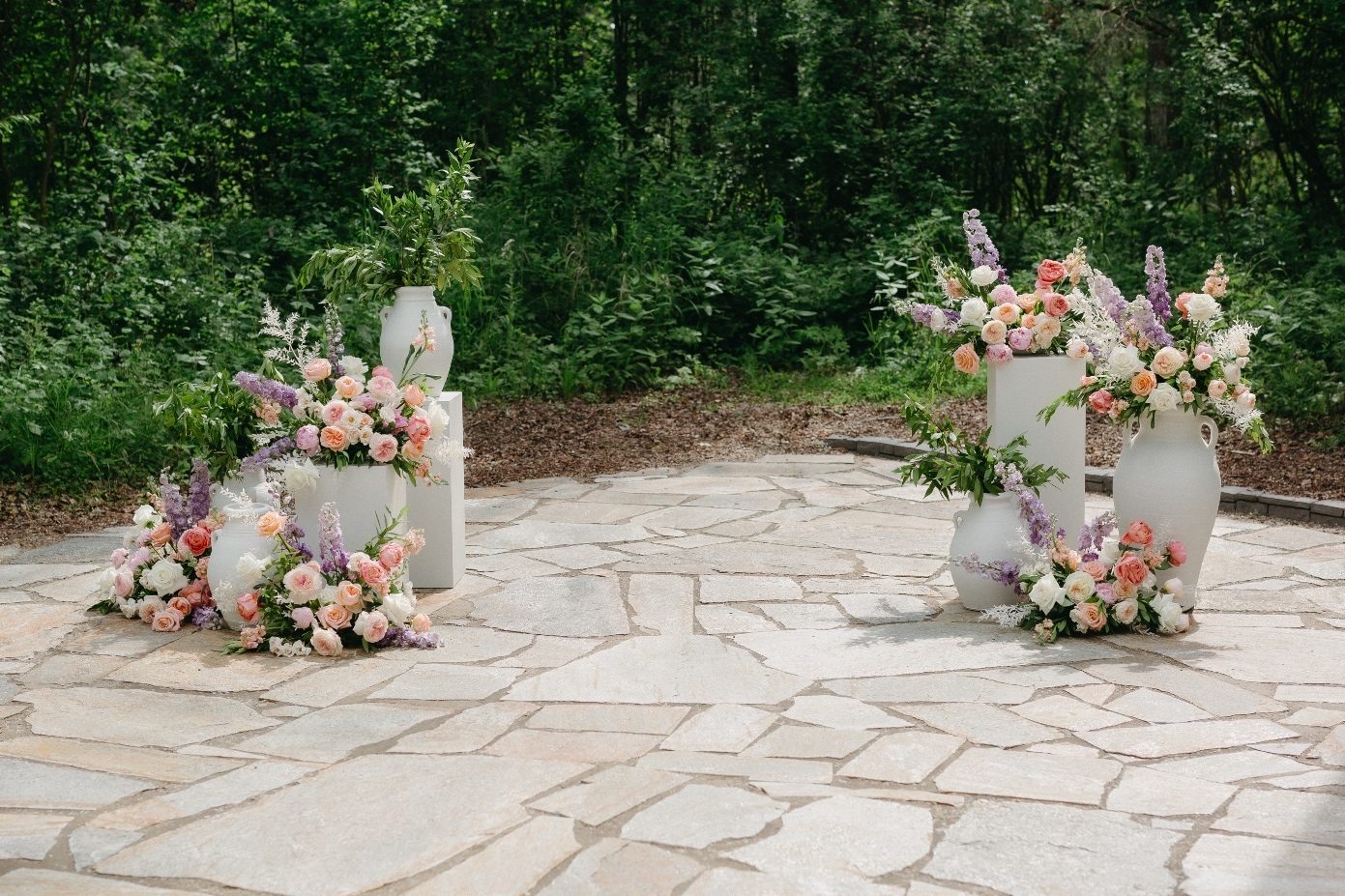 Alter Floral Decor As an alternative to an arch at the altar, a gardeny display on either side with a cluster of pillars and urns overflowing with greenery and pastel arrangements.