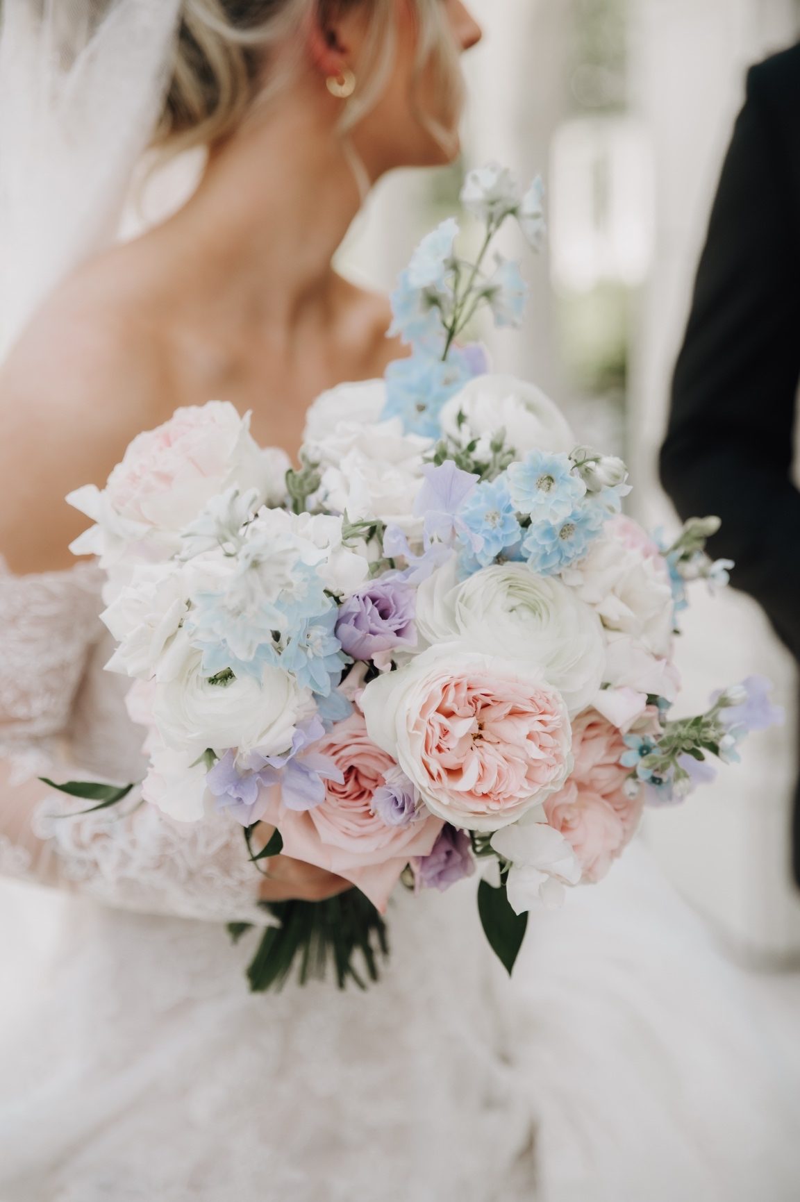 Kaylee's bridal bouquet, an assortment of delphinium, roses, sweet peas, ranunculus, lisianthus and tweedia.