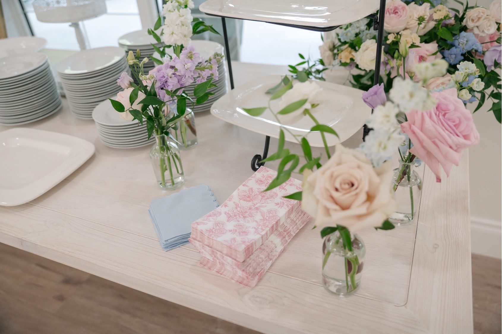 Cute assorted bud vases with clusters of gardeny blooms displayed on the dessert bar.