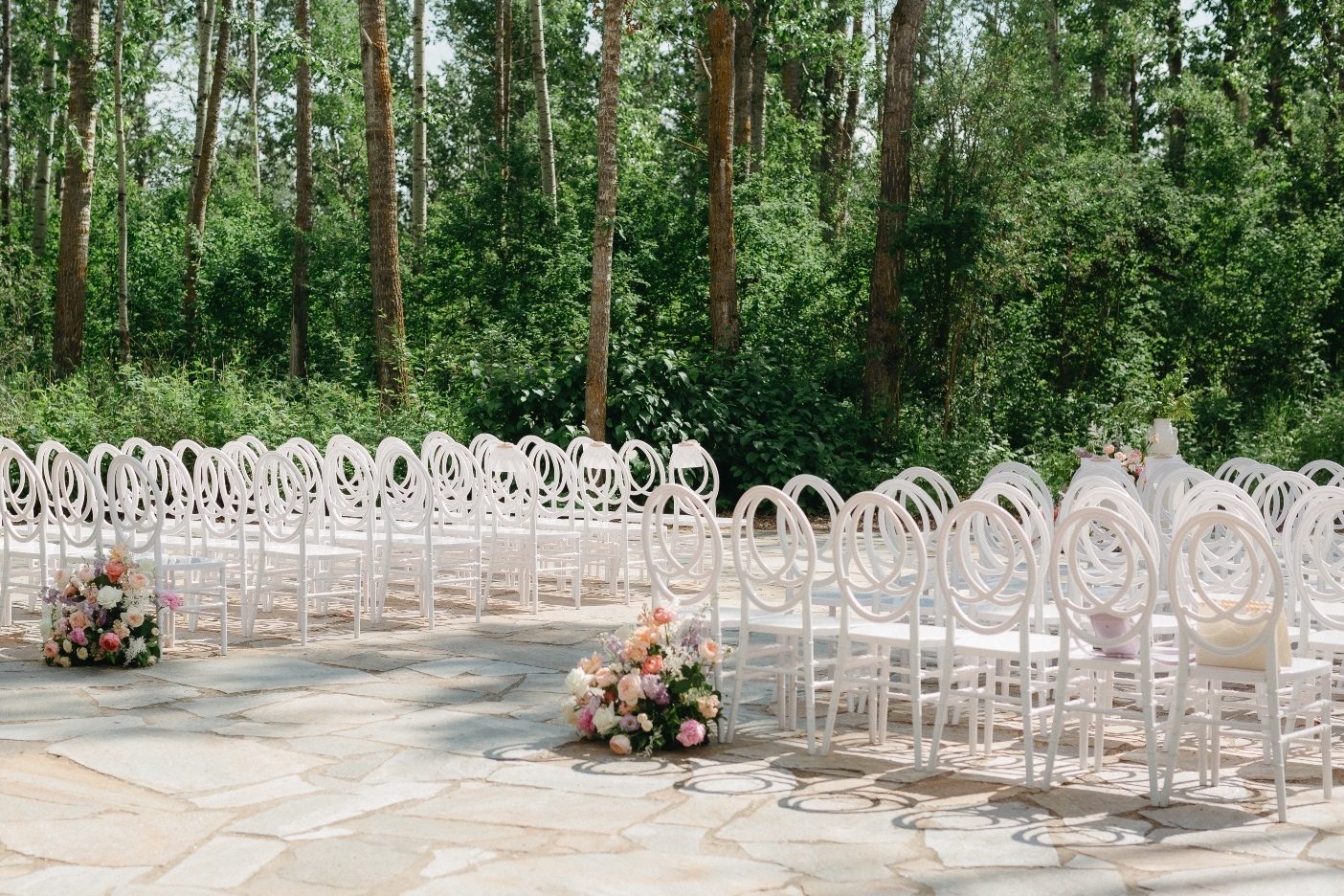 Ceremony at Sparrow Lane Before the ceremony starts, with all the white chairs neatly lined up and two beautiful pastel arrangements displayed at the start of the aisle.