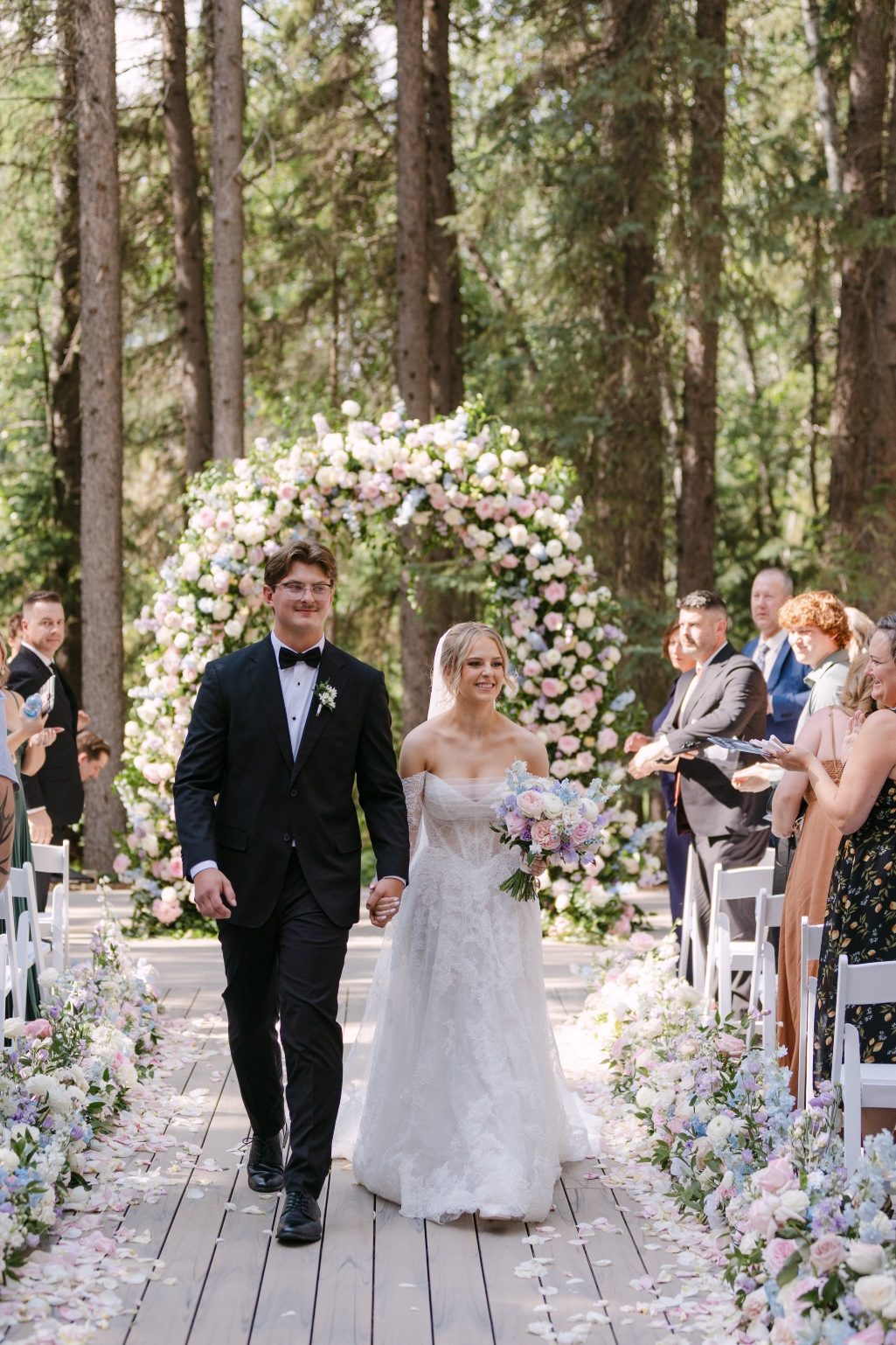Happy Couple Kaylee and Oran are officially Mr. and Mrs., holding hands and walking down the aisle exiting the ceremony.