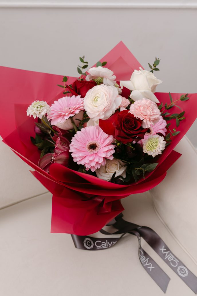 The Claire hand tied bouquet from our Valentine's Day collection featuring a mix of blooms in white, pink and burgundy finished off with an elegant wrap of Korean paper.