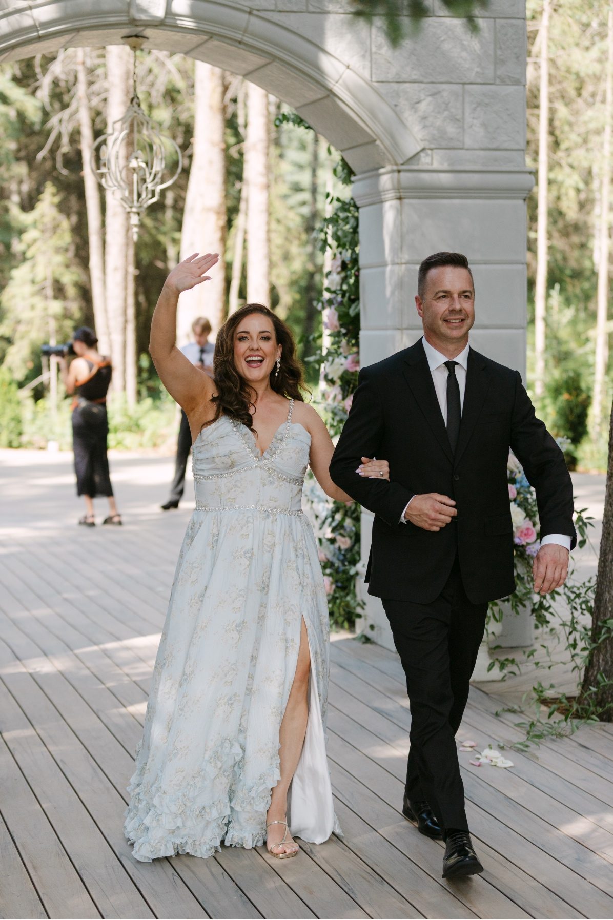 LNP1-2650 Kaylee's parents exiting the ceremony, Lindsay's hand is in the air, happily celebrating her daughter's marriage.