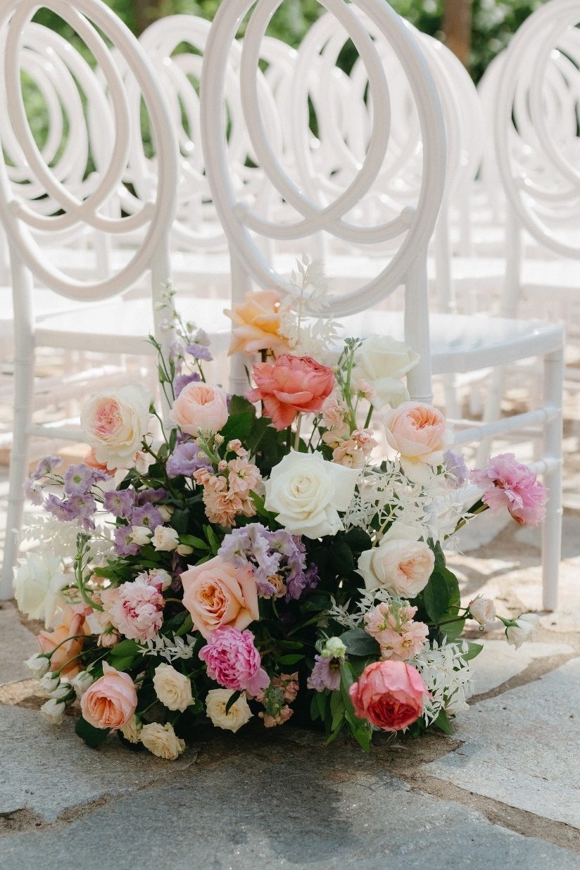 Start of Aisle Arrangement A fabulous, gardeny arrangement at the start of the aisle full of pastel blooms including peonies, roses, lisianthks, ranunculus, stock and greenery.