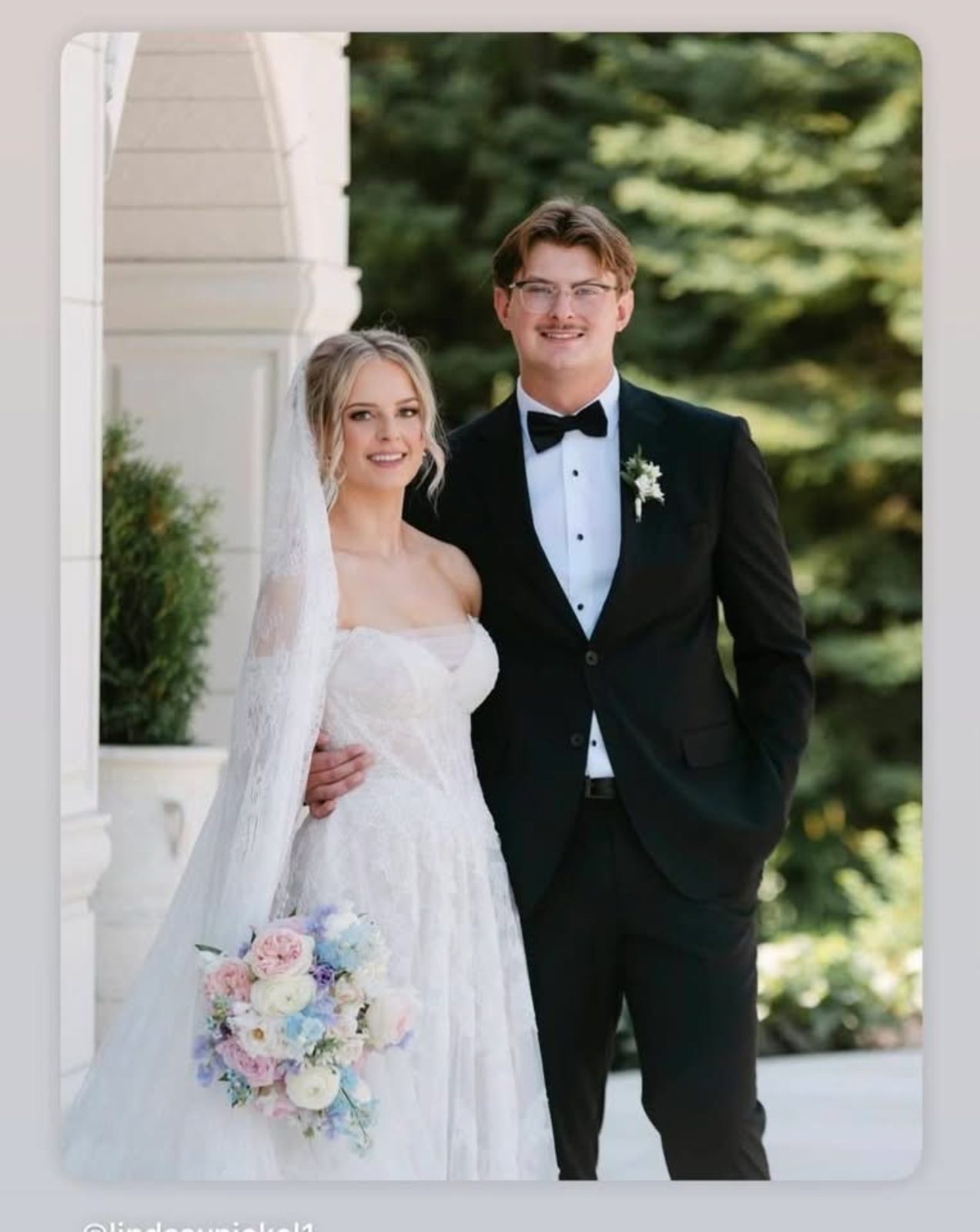 Luxury wedding portrait with bride and groom holding bouquet with garden roses in pastel tones of blush, pink, pale blue and lavender, light purple at Archway Manor
