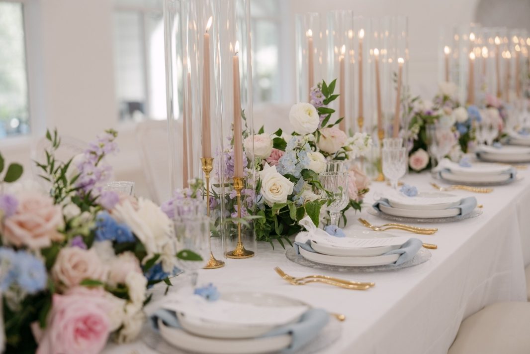 Grand luxury wedding reception long table floral centerpiece with flowers and candles using garden roses in pastel tones of white, blush, pink, pale blue and lavender, light purple at Archway Manor