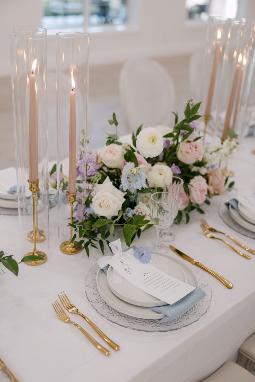 Grand luxury wedding reception long table floral centerpiece with flowers and candles using garden roses in pastel tones of white, blush, pink, pale blue and lavender, light purple at Archway Manor