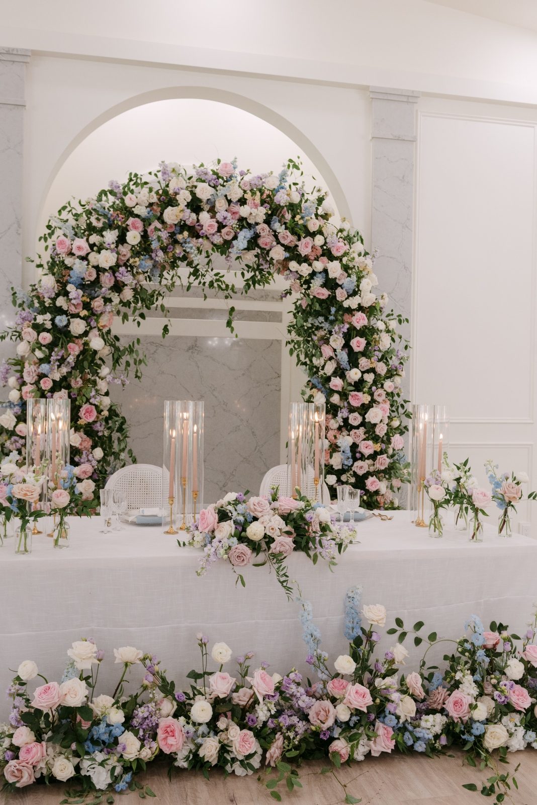 Grand luxury archway head table floral installation with garden roses in pastel tones of blush, pink, pale blue and lavender, light purple at Archway Manor