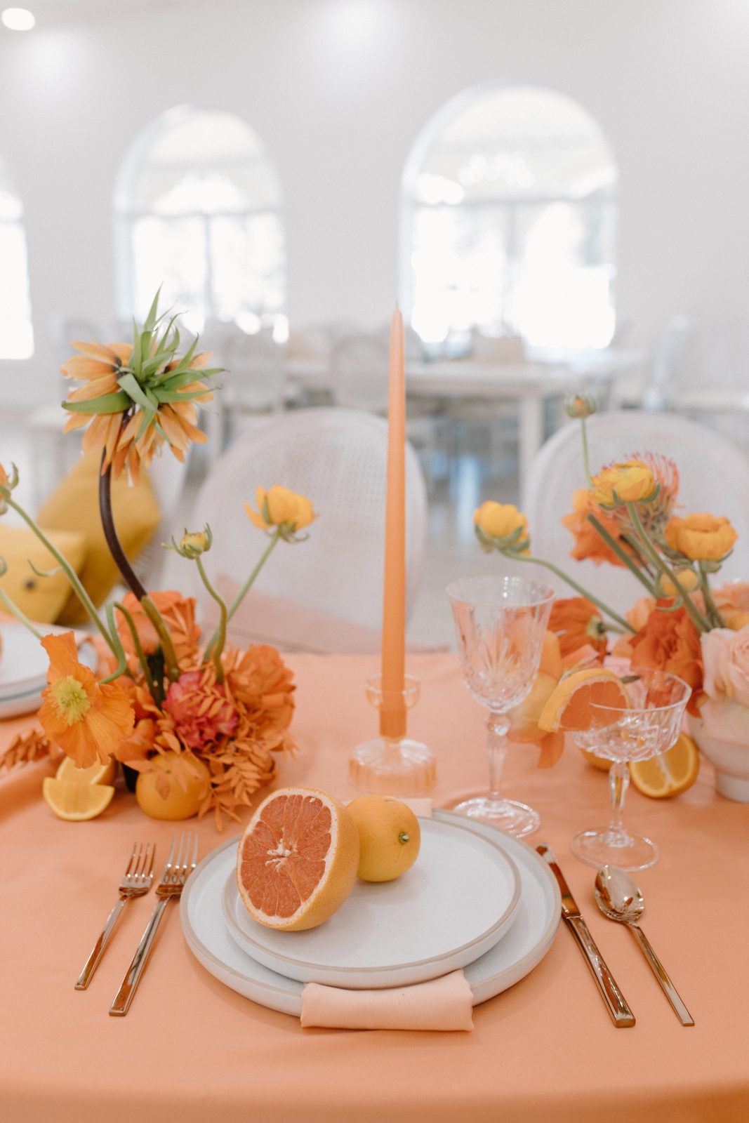 Colorblocked wedding centerpiece in bright citrus tones of orange, and yellow, including unique Fritillaria and grapefruit