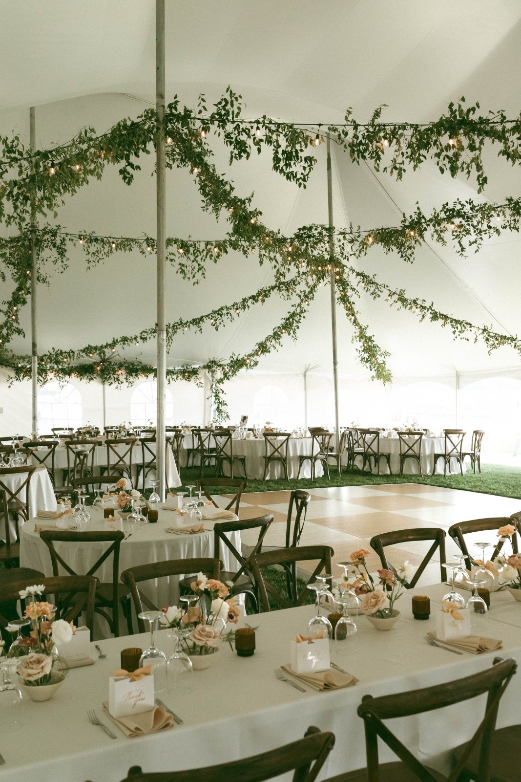 Luxury tent wedding greenery smilax ceiling decor string lights. ikebana centerpieces terra cotta and white flowers