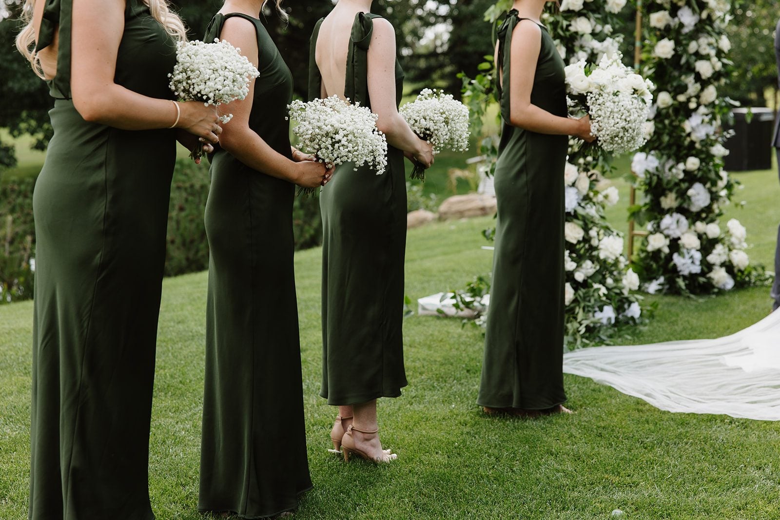 Cassidy + Adon Bridesmaids wear green dresses and hold baby's breath bouquets for this green and white Hilltop Wedding Ceremony.