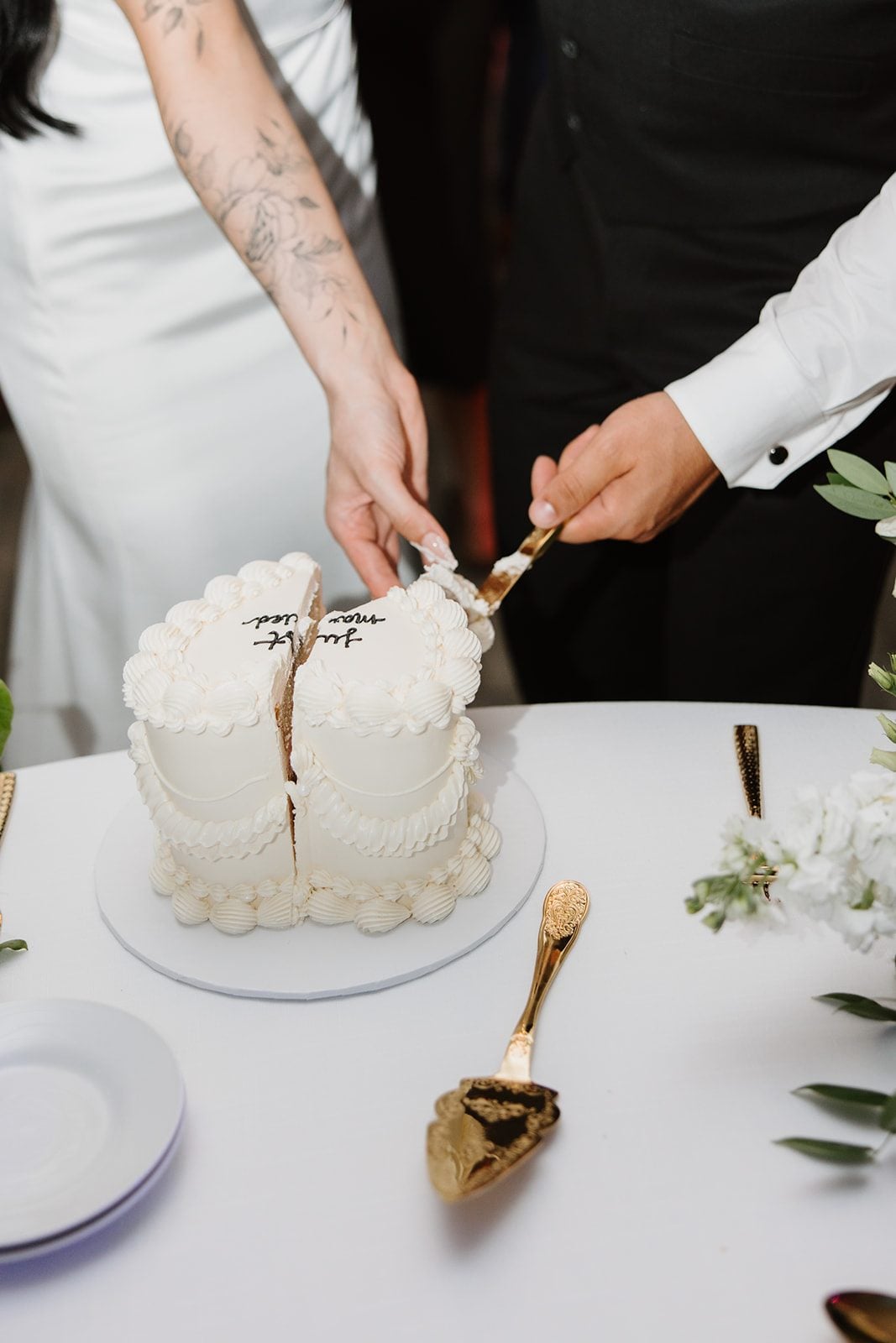 Cassidy + Adon Calyx couple cut their heart shaped cake together at their Hilltop wedding reception.