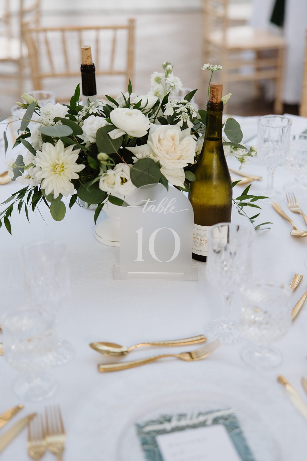 Cassidy + Adon An organically styled centrepiece for the guest tables in green and white flowers featuring dahlias, ranunculus, roses, eucalyptus.