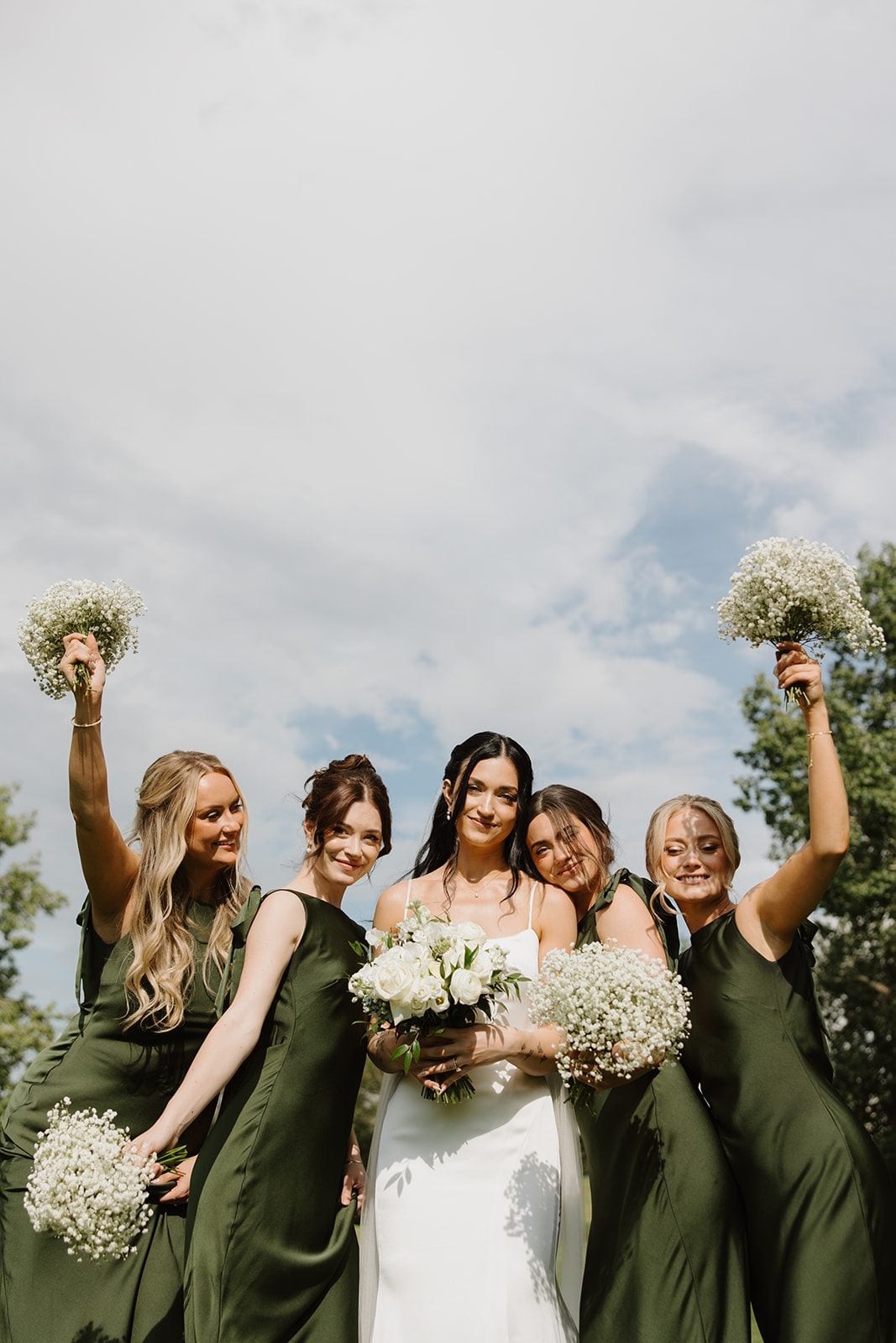 Cassidy + Adon The bride and bridesmaids for green and white wedding at Hilltop, brides wearing green satin gowns and carrying baby's breath bouquets and the bride with a gorgeous white bridal bouquet.