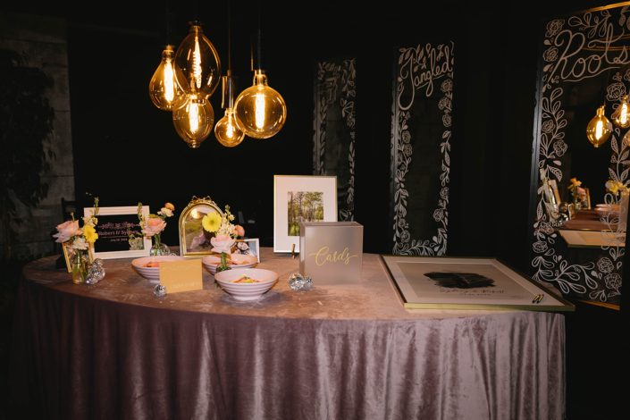 The guestbook/giftcard with several pastel bud vases with gardeny blooms and mini disco balls for decor.