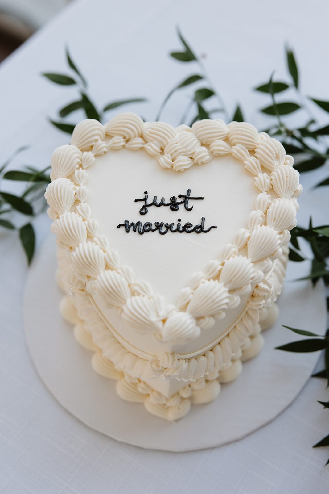 Cassidy + Adon Ivory heart shaped wedding cake with sprigs of Italian ruscus to compliment the green and white colour scheme.