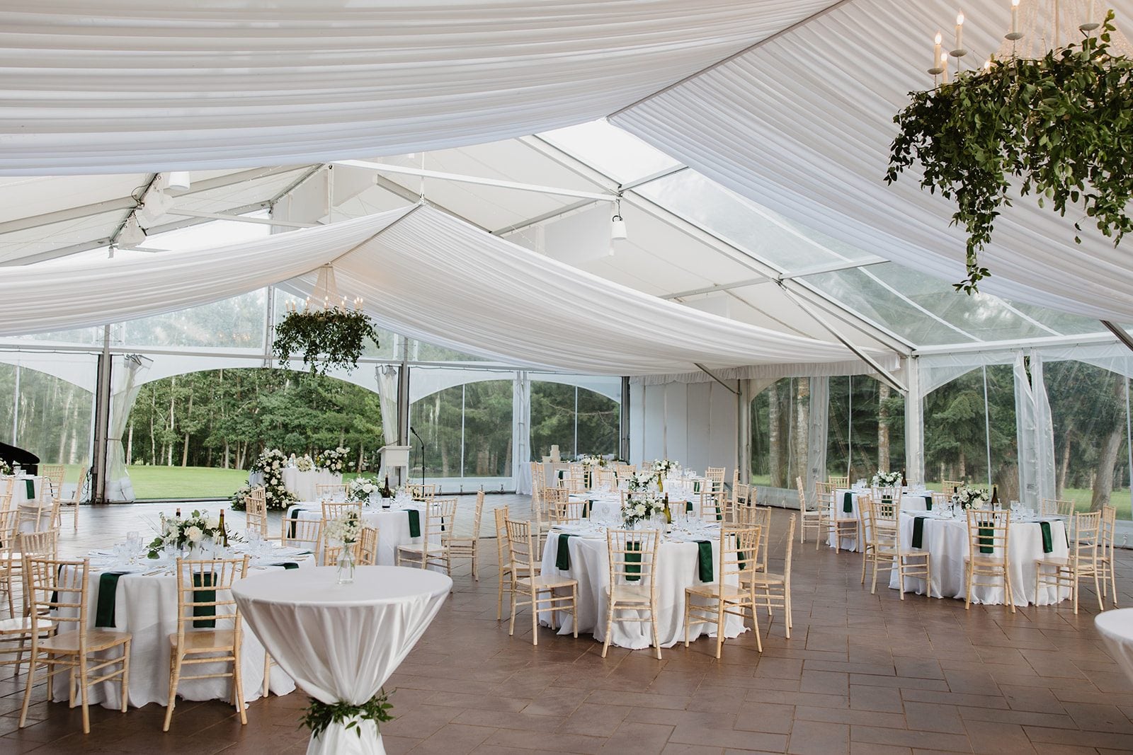 Cassidy + Adon Reception set up at Hilltop wedding centre in white and green featuring hanging greenery chandeliers, green and white centrepieces, and beautifully styled guest tables.