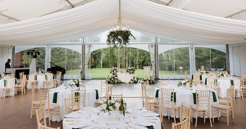 Hilltop Reception Space FT Reception set up at Hilltop Wedding Center for a green and white wedding, featuring greenery chandeliers, green and white floral centrepieces and a sweetheart table beautifully decorated with green and white floral arrangements.