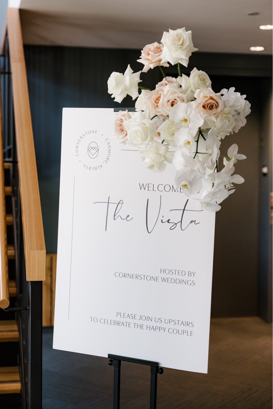 Welcome Sign Welcome sign at venue entrance styled with a cluster of white and blush roses in the foreground.