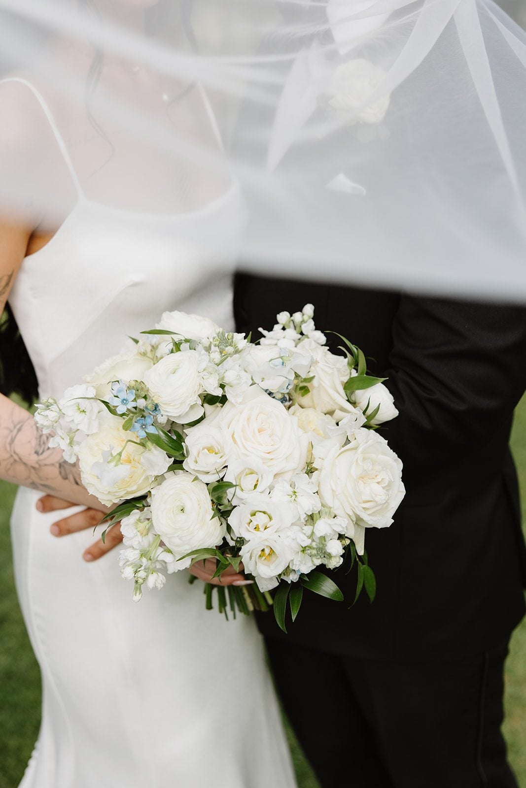 Cassidy + Adon The brides timeless white bridal bouquet with roses, ranunculus, lisianthus sweet peas with eucalyptus and Italian ruscus.