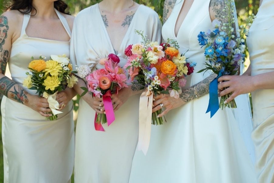 Colourful Bouquets Close up of the bridal party bouquets, three monochromatic bouquets (one yellow, one pink, one blue) and the bride's colourful bouquet, with a mix of all the bright tones.