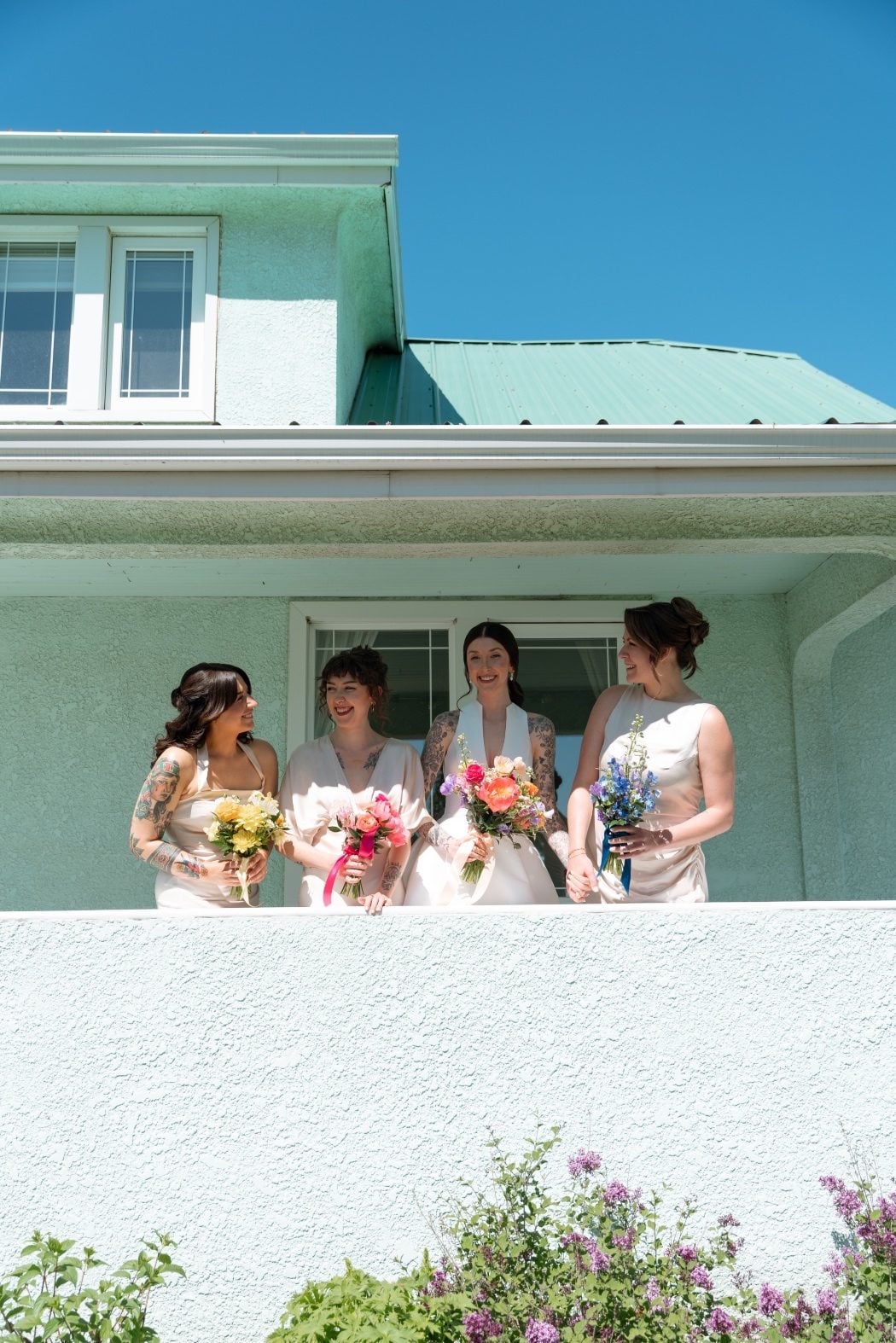 Colourful Bridesmaid Bouquets The bride with her bridesmaids wearing champagne gowns and colourful bouquets at River's Edge.