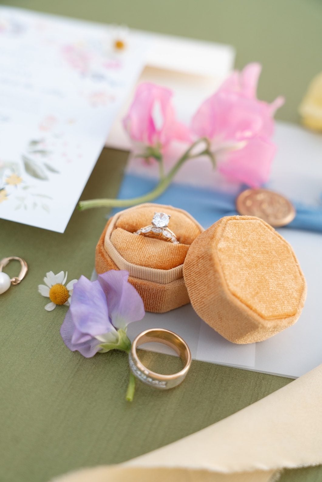 Colourful Flatlay Flatlay of brides ring and ring box with colourful garden blooms, like sweet pea and chamomile.