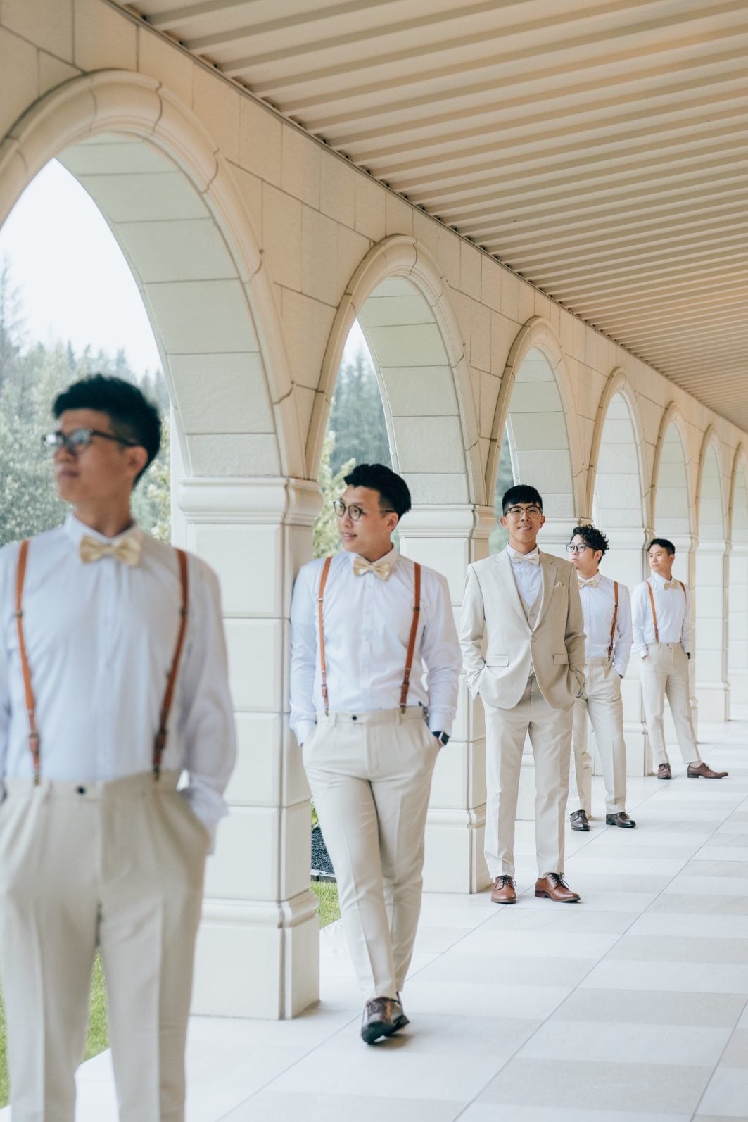 Groom poses with his groomsmen, each at their own arch.