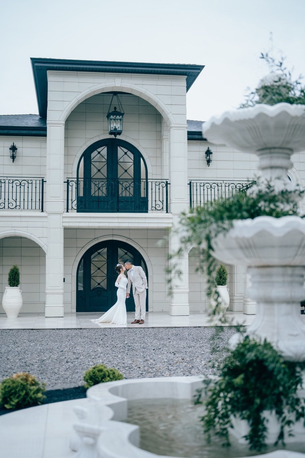 Romantic kiss between bride and groom outside Archway Manor.