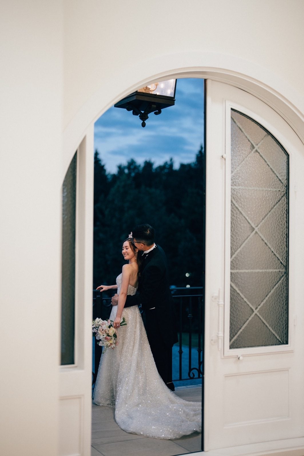 Bride and groom on Archway Manor balcony in the fading light..