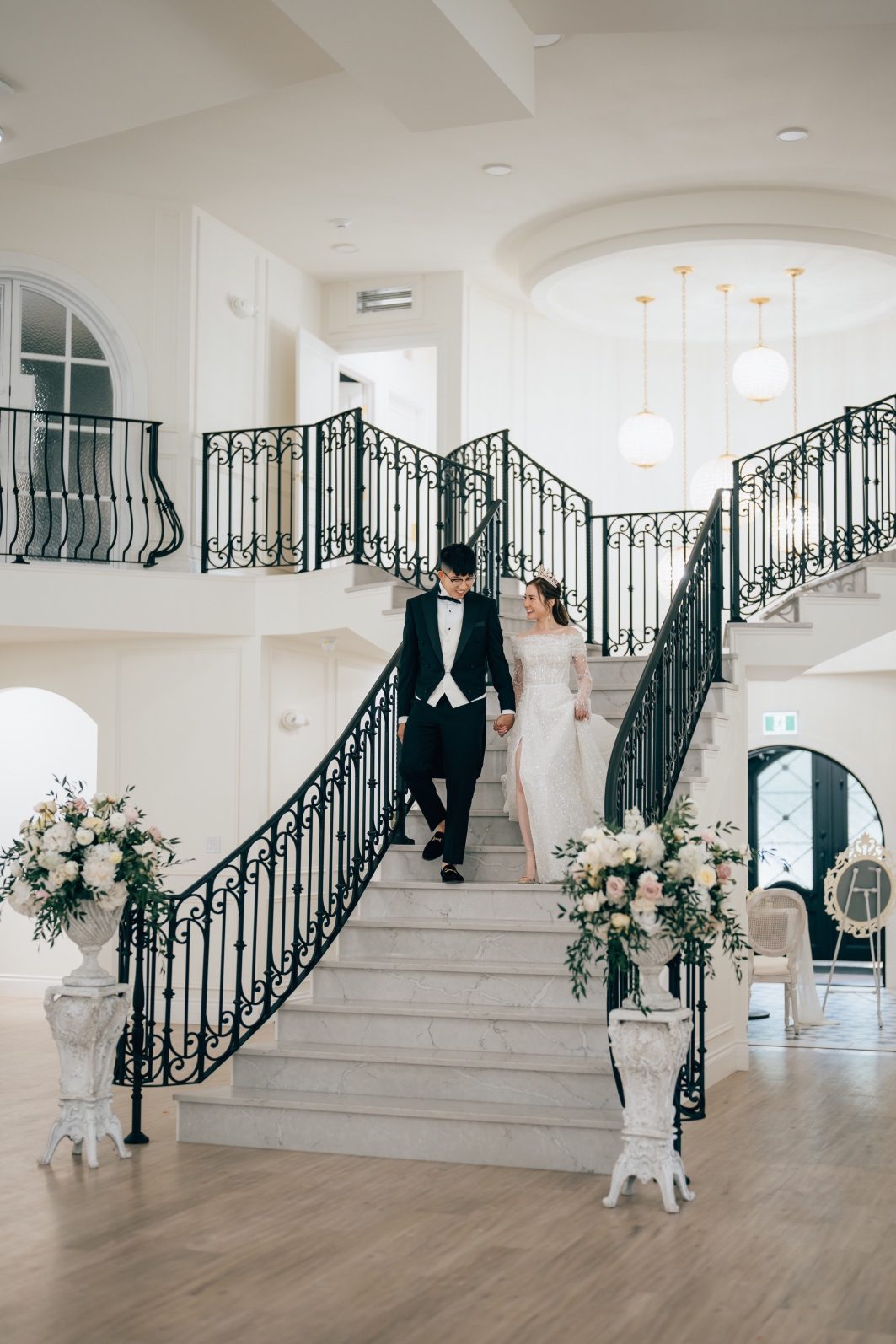 Bride and Groom in their formal reception attire descending the grand staircase at Archway Manor.
