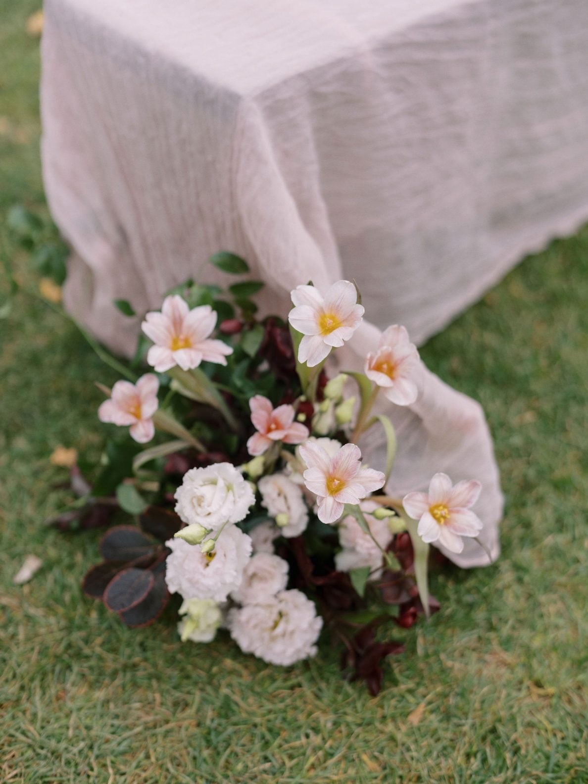 Justine Milton True to Hue Aisle Arrangement A close up of an aisle arrangement with lisianthus, tulips, smokebush, hellebores and ruscus.