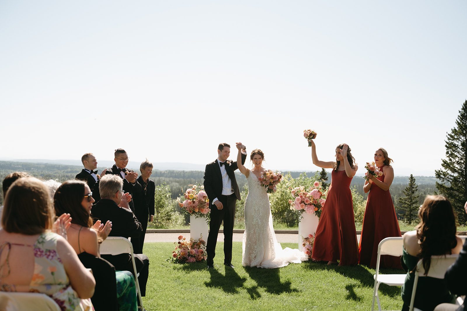 Mr. and Mrs. the couple raise their held hands in celebration before exiting the ceremony.