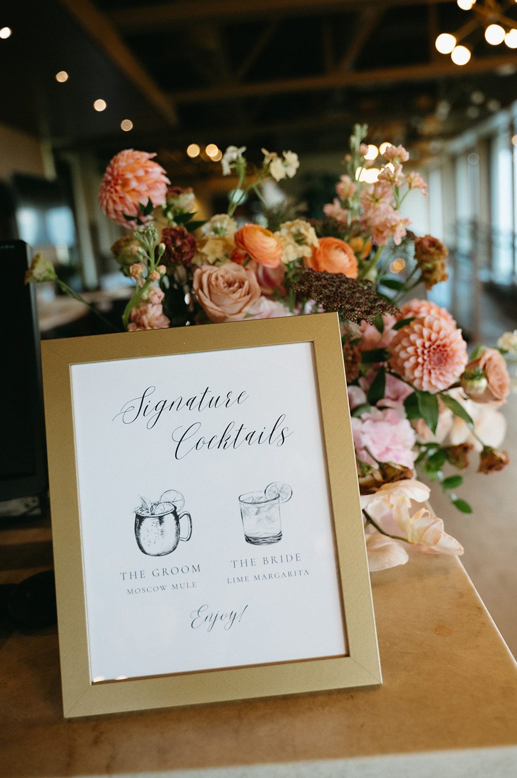 Signage for signature cocktails for this pink and peach wedding reception at Pinebrook Golf & Country Club.