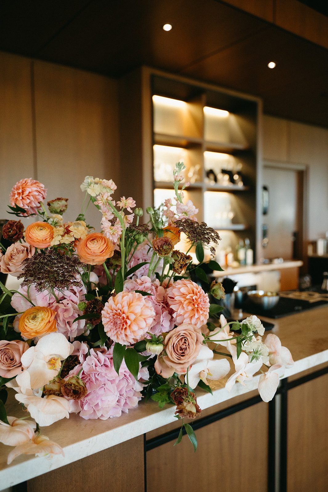 Gorgeous pink and peach arrangement for the bar at Pinebrook Golf & Country Club with dahlias, ranunculus, orchids, chocolate lace, roses, hydrangea, phlox, lisianthus and stock.