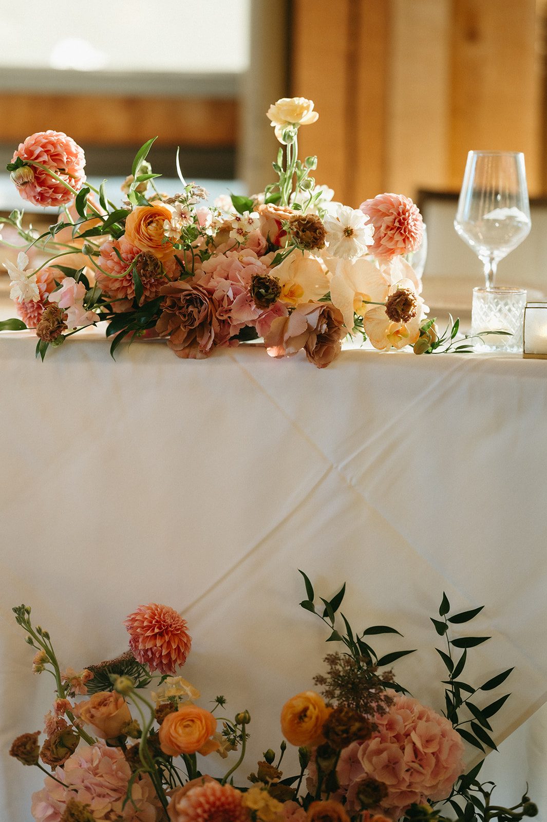 Sunbeams highlighting the garden blooms in this pink and peach arrangement accenting the head table.