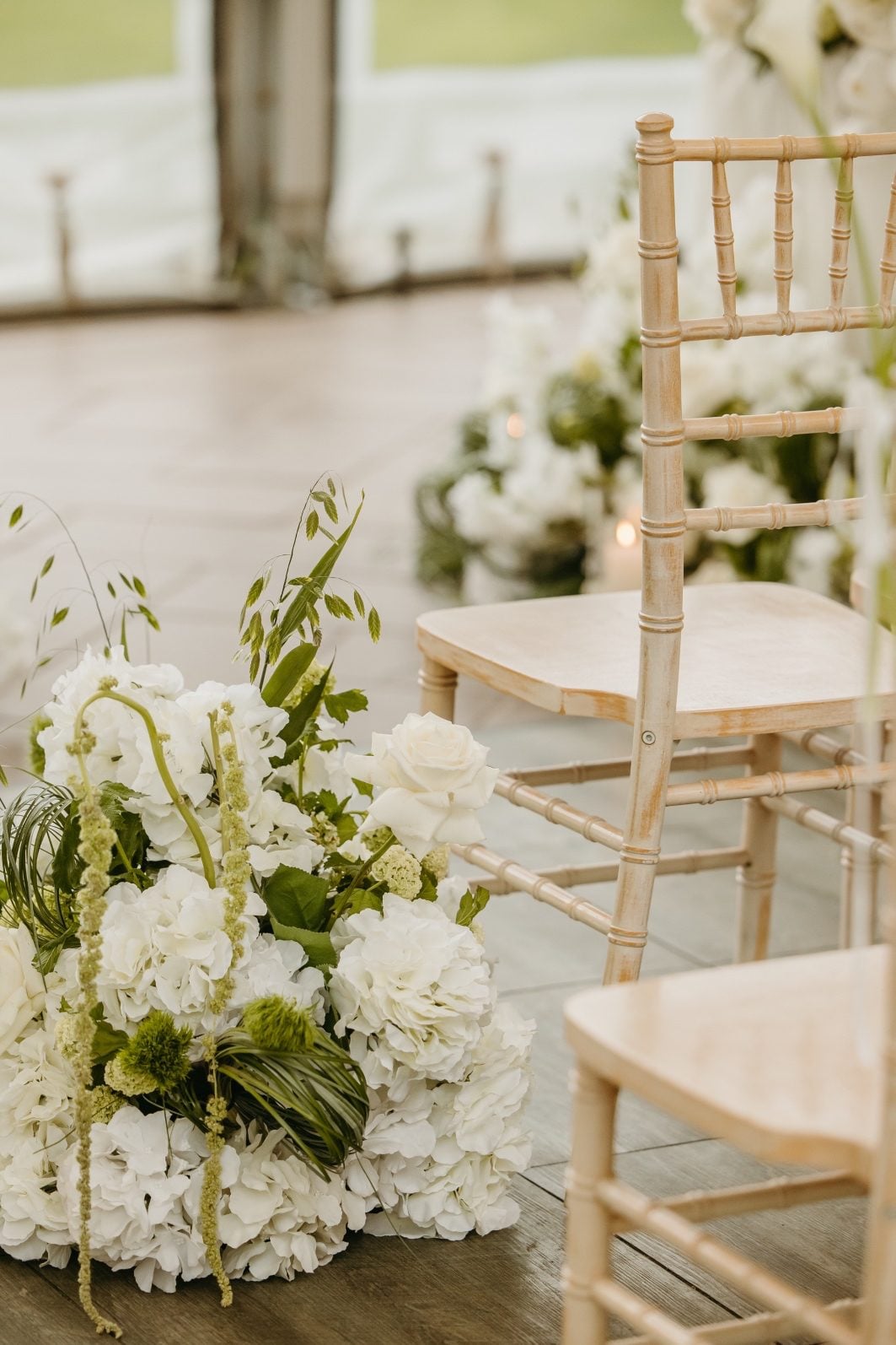 White + Green Wedding Flowers Aisle Arrangement White and green wedding flower aisle arrangement, generous in size following the curves of the aisle.