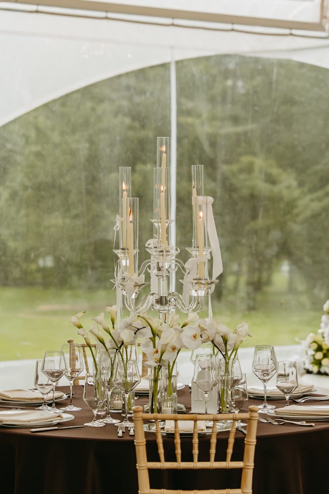 White and Green Wedding Flower Centrepiece Crystal candelabra with ivory tapers surrounded by bud vases of green and white wedding flowers including callas and orchids.