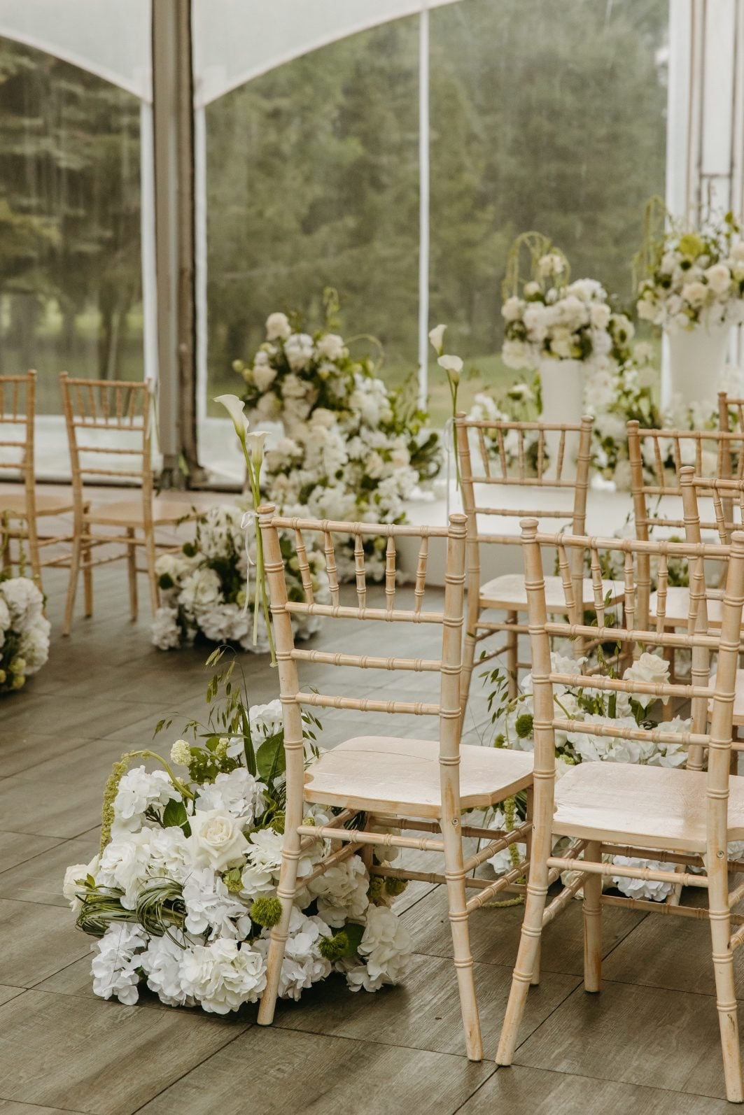 White and Green Wedding Flowers Aisle Mini ceremony set up featuring stunning green and white wedding flowers including aisle arrangements, calla "pew markers", and a circular altar adorned with large, overflowing arrangements.