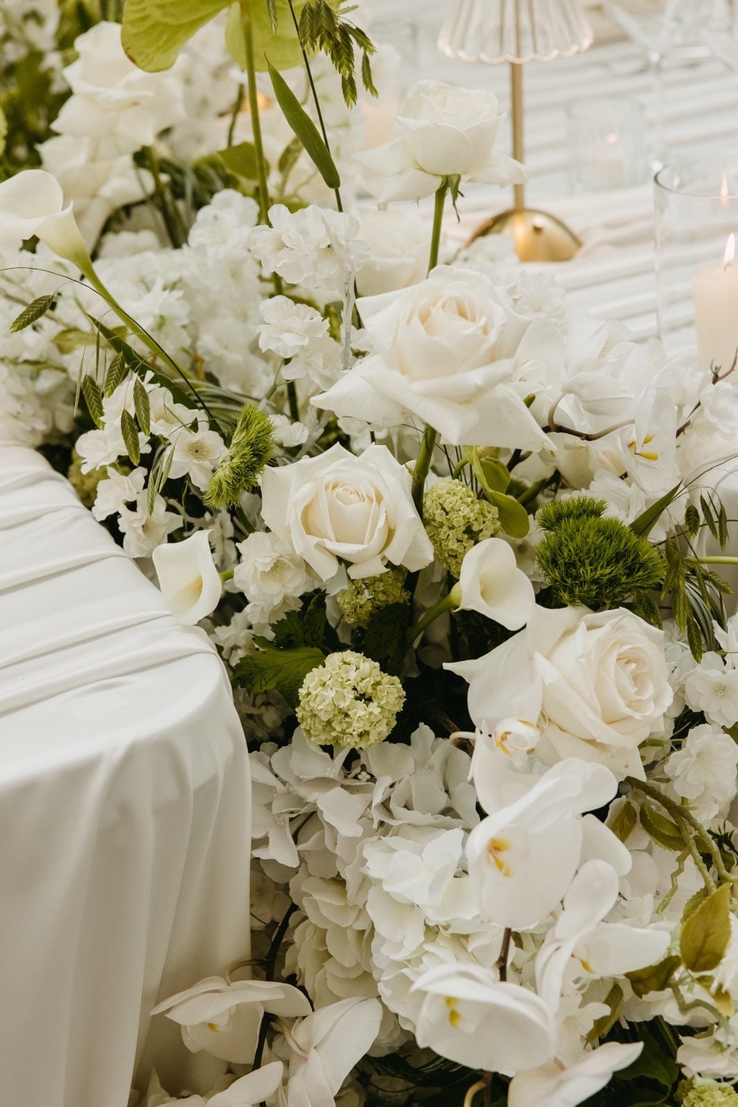White and Green Wedding Flowers Close Up Close up of the fresh white and green wedding flowers running down the length of the huge featured table, including hydrangea, roses, orchids, viburnum, orchids, amaranths, anthurium and decorative grasses.