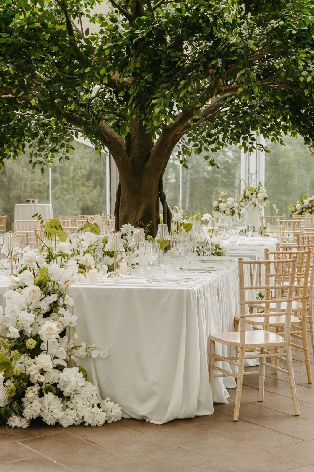 White and Green Wedding Flowers Headtable Immersive feature table, with a large artificial tree blossoming from the middle, green and white wedding flowers running the entire length of the table and cascading over the side.