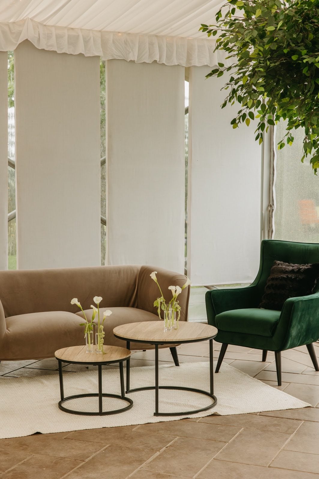 White and Green Wedding Flowers Sitting Area Cozy sitting area in the corner of the tent with a taupe modern couch, suade emerald chair and wood tables accented with white and green bud vases.