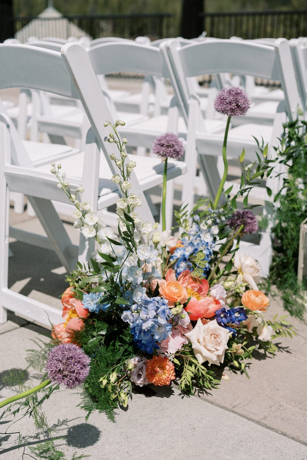 Lottie Colourful garden inspired aisle flowers with peonies, delphinium and allium at a Fairmont Banff Springs wedding.