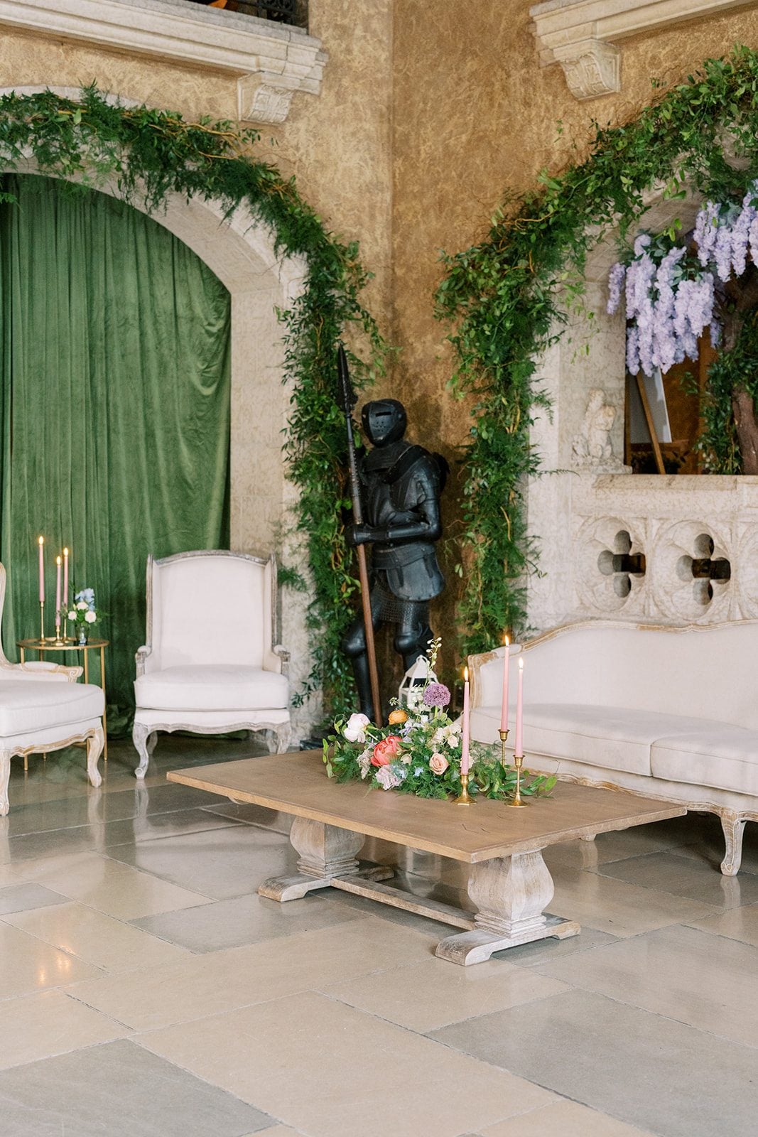 Lottie Wedding lounge at the Fairmont Banff Springs framed by lush greenery, blush taper candles and a colourful floral arrangement.