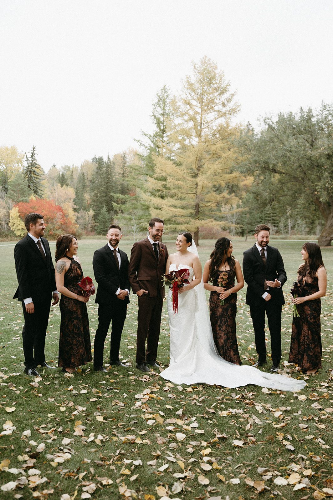 Andi + Logan Fall wedding party in rich brown and black with sculptural wedding flowers in burgundy tones.
