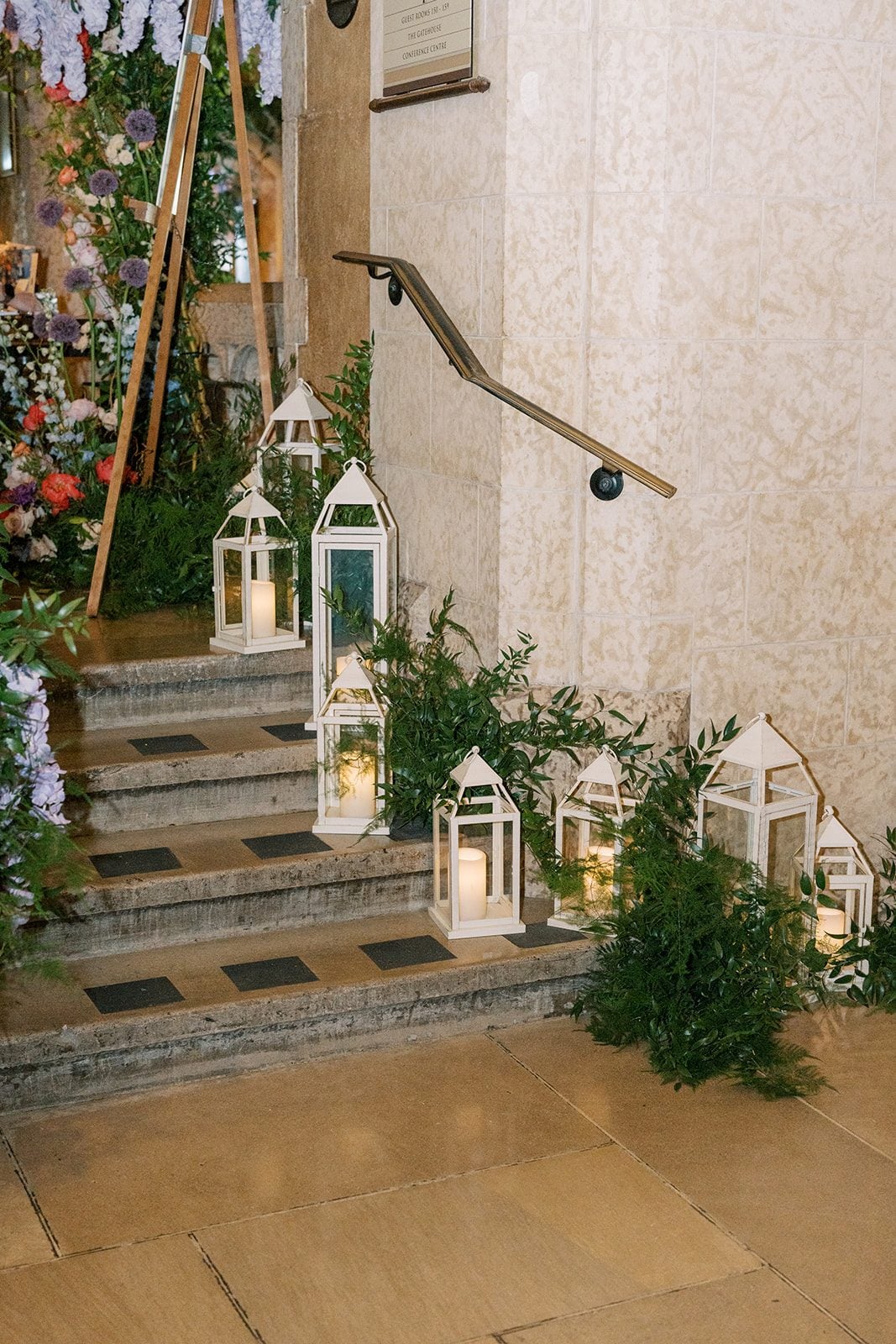 Lottie White lanterns and candles surrounded by lush greenery along the stone steps at the Fairmont Banff Springs.