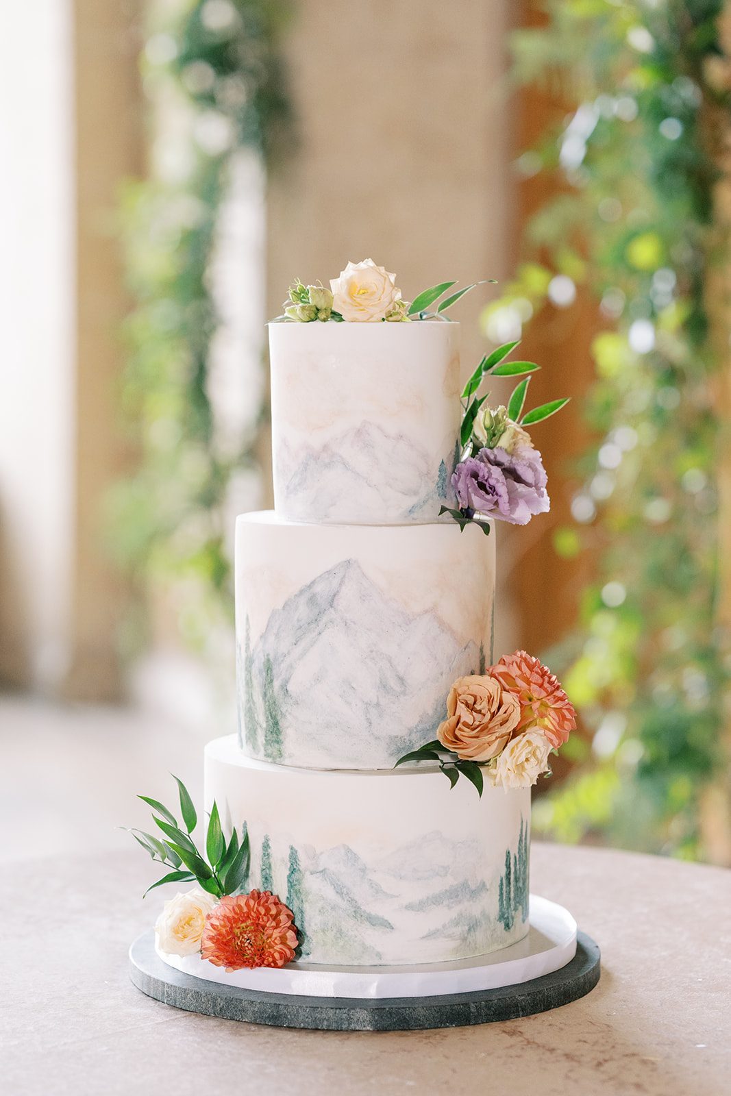 Lottie Hand painted mountain wedding cake with colourful floral accents at the Fairmont Banff Springs.